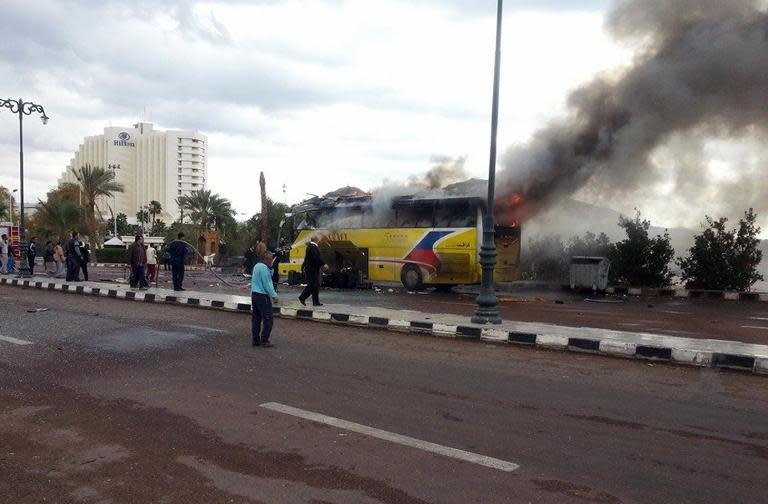 A picture taken on February 16, 2014, shows flames rising from the wreckage of a tourist bus at the site of a bomb explosion in the Egyptian south Sinai resort town of Taba