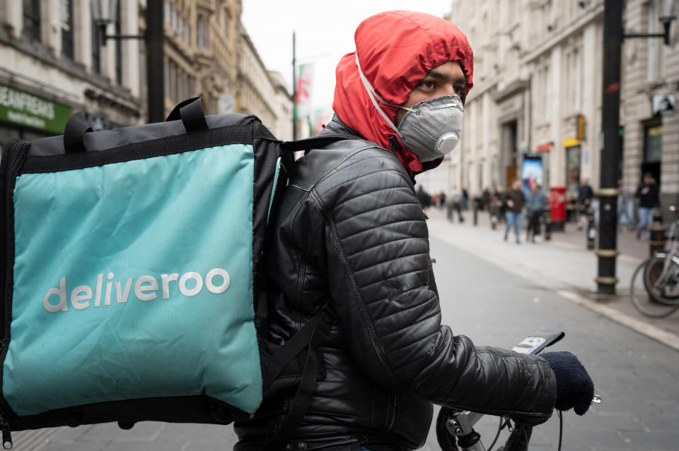 CARDIFF, UNITED KINGDOM - MARCH 14: A Deliveroo rider wears a surgical face mask in Cardiff city centre on March 14, 2020 in Cardiff, United Kingdom. Coronavirus (Covid-19) has spread to over 149 countries in a matter of weeks, claiming over 5,600 lives and infecting nearly 150,000. As of today, there are over 1000 diagnosed cases in the UK and 21 deaths. (Photo by Matthew Horwood/Getty Images)