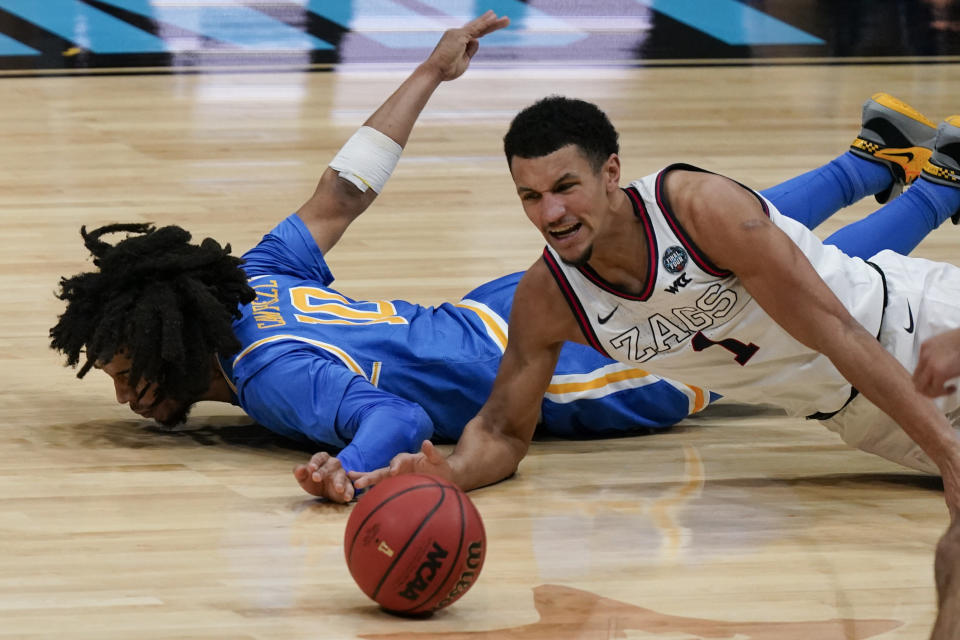 Gonzaga guard Jalen Suggs (1) scrambles for a loose ball with UCLA guard Tyger Campbell (10) during the second half of a men's Final Four NCAA college basketball tournament semifinal game, Saturday, April 3, 2021, at Lucas Oil Stadium in Indianapolis. (AP Photo/Michael Conroy)