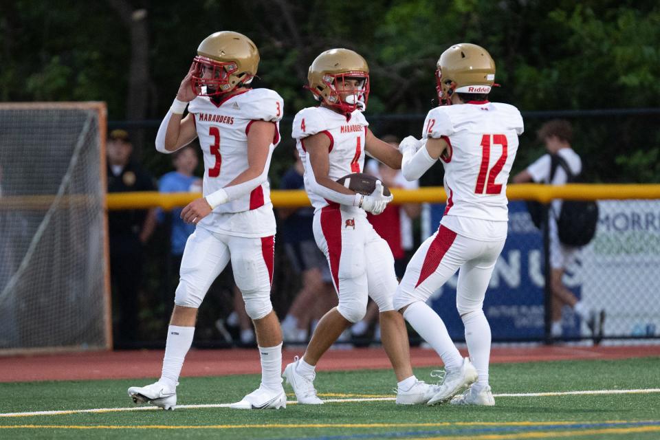 September 14, 2023; Mount Olive HS Jekori Zapata (4) celebrates his touchdown with teammates Lincoln Youth (3) and Morristown HS Vincent Carpini (12) against Morristown HS in Morristown, New Jersey, USA; Morristown High School. Mandatory Credit: Tom Salus-The Record