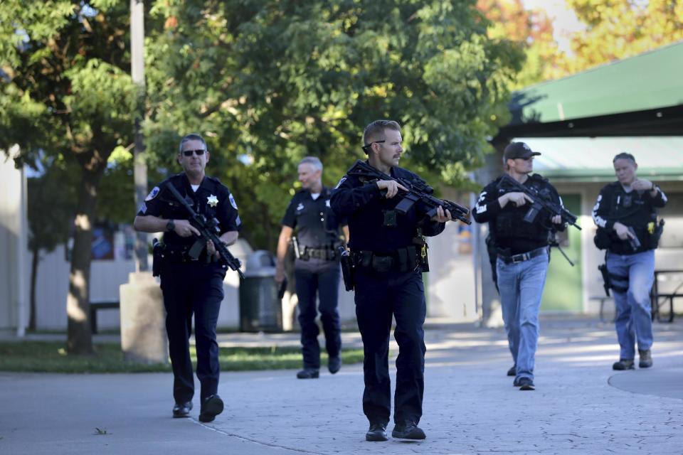 Santa Rosa police officers search the campus of Ridgway High School after the shooting nearby (AP)