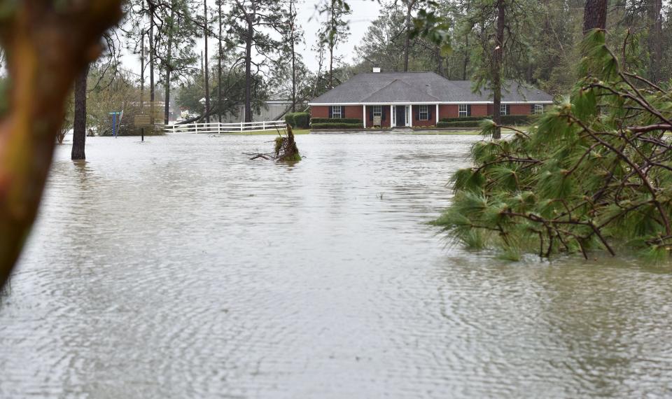 A house at the corner of Alabama State Route 59 and Municipal Park Drive, Loxley, Ala., is overtaken by floodwater.