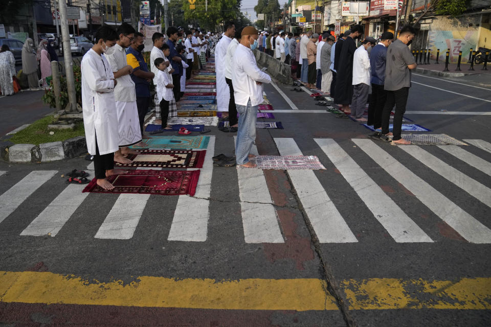 Muslim men perform Eid al-Fitr prayer marking the end of the holy fasting month of Ramadan, on a street outside an overflowed mosque in Jakarta, Indonesia, Monday, May 2, 2022. (AP Photo/Dita Alangkara)