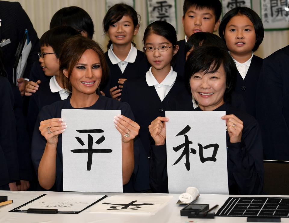 U.S. first lady Melania Trump and Akie Abe, wife of Japanese Prime Minister Shinzo Abe, write the word "peace" in Japanese. (Photo: Anadolu Agency via Getty Images)