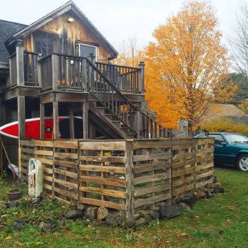 A pallet fence is used in a person's backyard. 