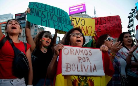 People celebrating Bolivian President Evo Morales' resignation, in Buenos Aires - Credit: JOSE LUIS PERRINO/AFP