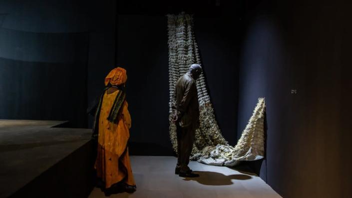 Viewers admire a piece by Senegalese artist Aissa Dione at the opening of the Black Rock gallery. The artwork looks like a hammock-like structure.