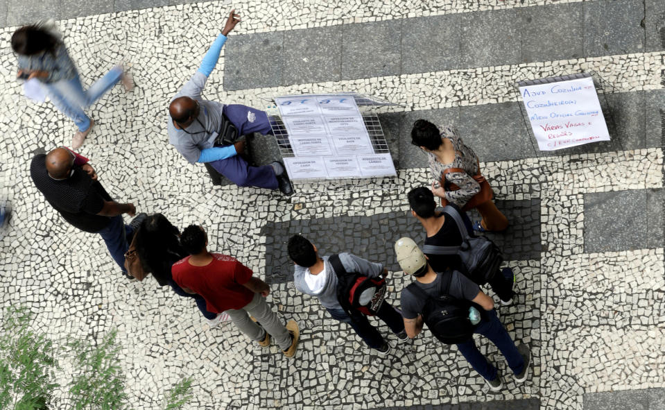 People look at lists of job openings posted on a street. January 9, 2018. REUTERS/Paulo Whitaker