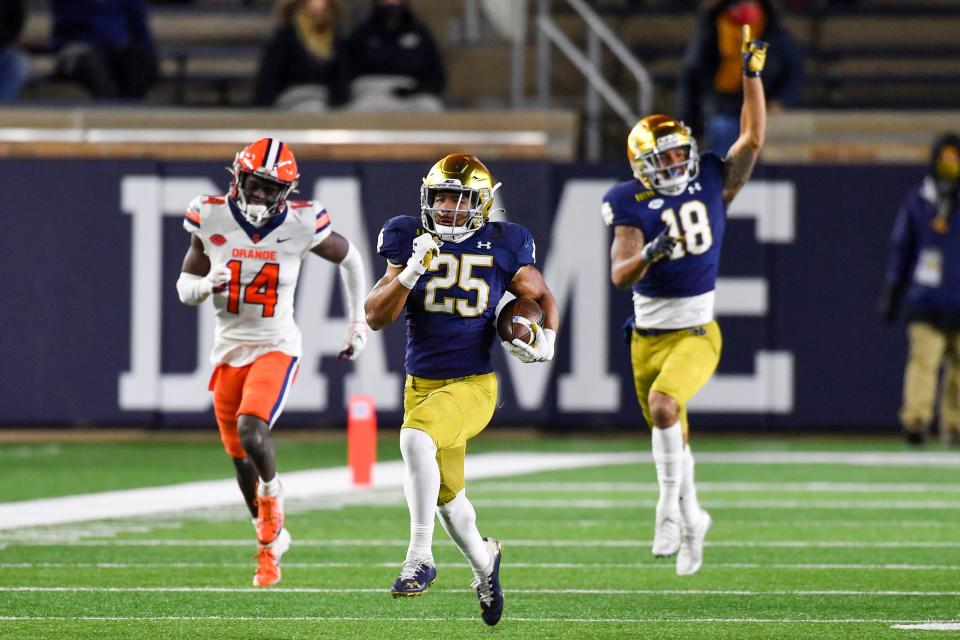 Notre Dame running back Chris Tyree (25) breaks free for a touchdown run as Syracuse cornerback Garett Williams pursues at Notre Dame Stadium.