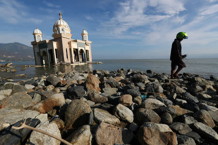 A local resident walks pass the remains of a mosque destroyed by the earthquake and tsunami in Palu, Central Sulawesi, Indonesia, October 5, 2018. REUTERS/Athit Perawongmetha