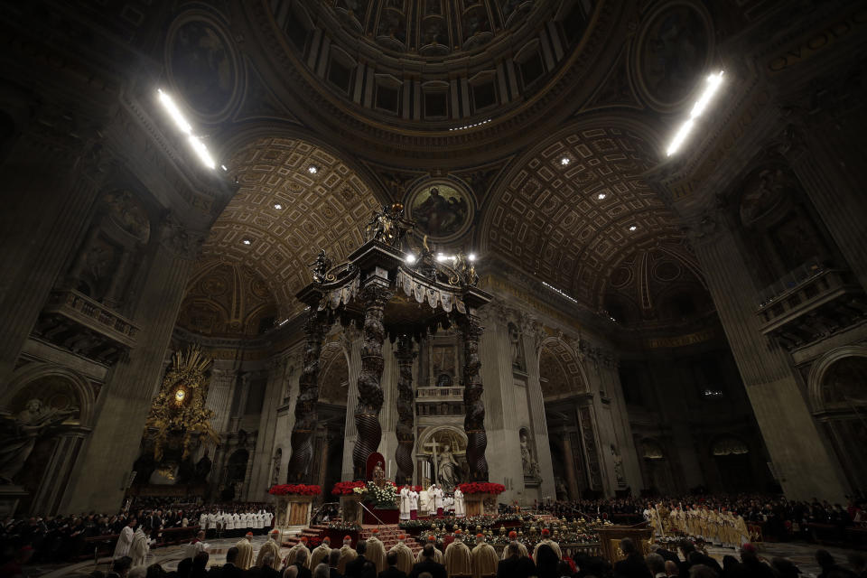 Faithful and prelates gather in front of the altar during the Christmas Eve Mass celebrated by Pope Francis in St. Peter's Basilica at the Vatican, Monday, Dec. 24, 2018. (AP Photo/Alessandra Tarantino)