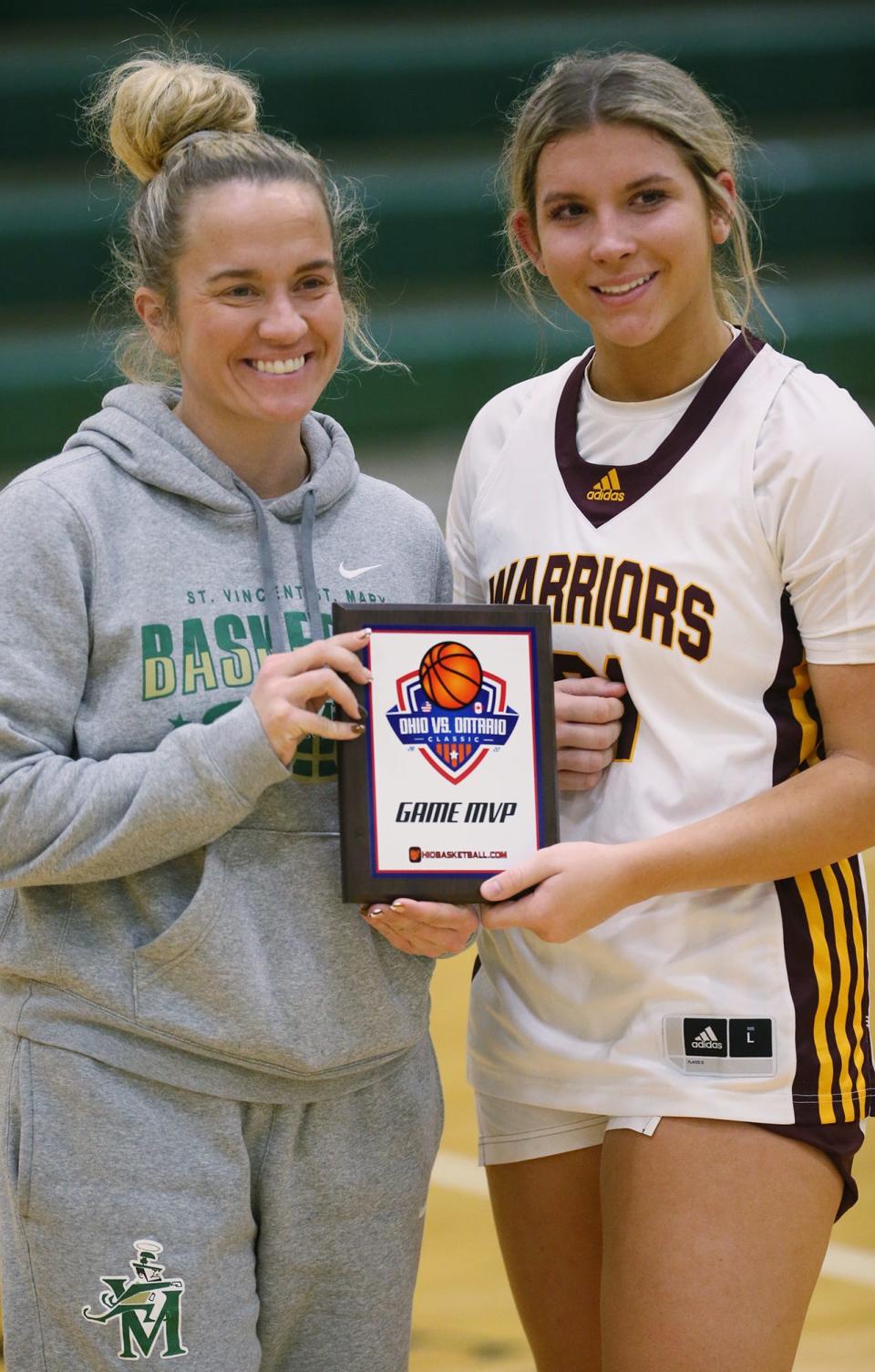 Carley Whitney, St. Vincent-St. Mary's Assistant Athletic Director, presents Walsh Jesuit's Megan Taraba the MVP award for the game against Excel Hoops in the Ohio vs. Ontario Classic at St. Vincent- St. Mary's High School on Saturday in Akron. Walsh Jesuit defeated Excel Hoops 43-31.