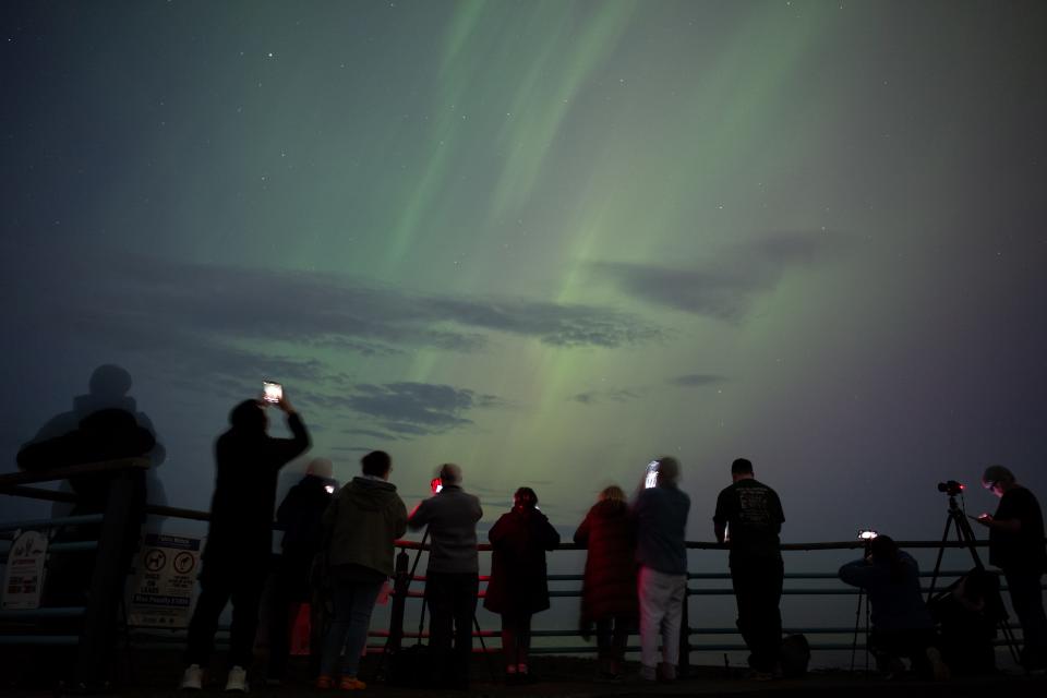 WHITLEY BAY, ENGLAND - MAY 10: People visit St Mary's lighthouse in Whitley Bay to see the aurora borealis, commonly known as the northern lights, on May 10, 2024 in Whitley Bay, England. The UK met office said a strong solar storm may allow northern parts of the UK the chance to see displays of aurora. (Photo by Ian Forsyth/Getty Images)