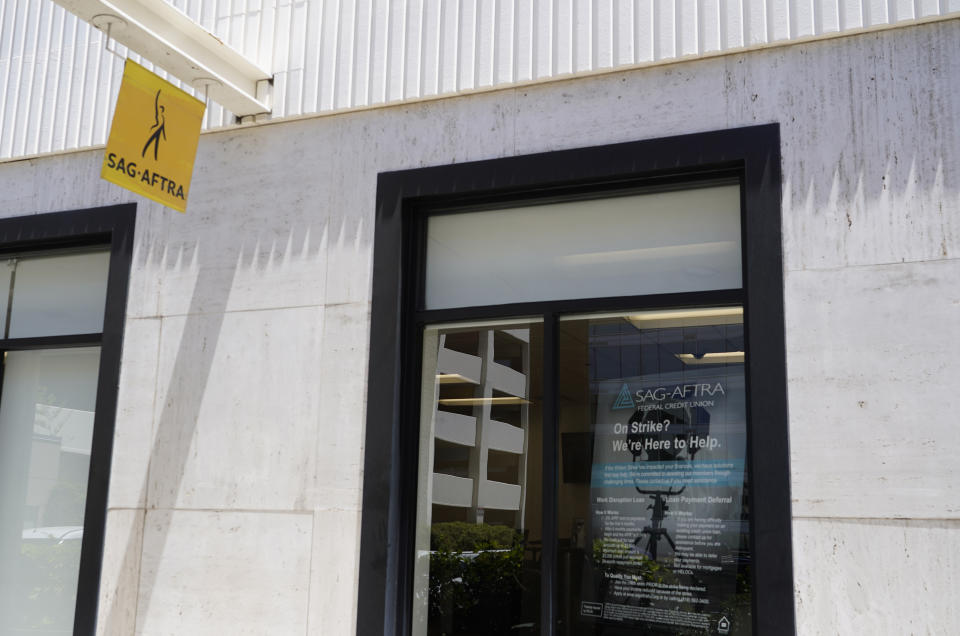 SAG-AFTRA federal credit union signage is visible in a window following a press conference announcing a strike by The Screen Actors Guild-American Federation of Television and Radio Artists on Thursday, July, 13, 2023, in Los Angeles. This marks the first time since 1960 that actors and writers will picket film and television productions at the same time. (AP Photo/Chris Pizzello)