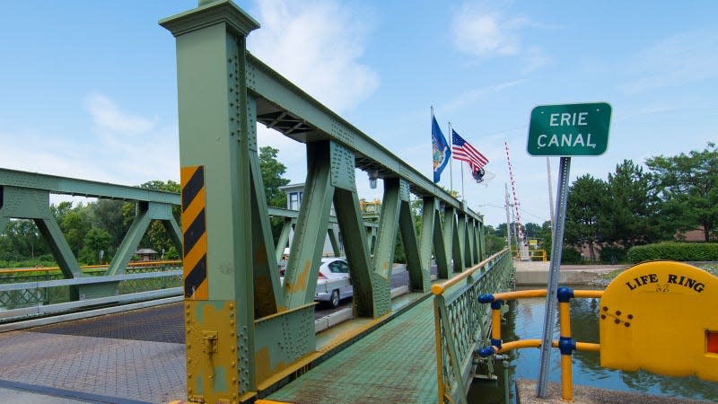 A photo of a green metal bridge over the Erie Canal. 