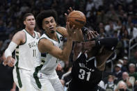 Milwaukee Bucks' Jordan Nwora (13) steals the ball from Brooklyn Nets' Paul Millsap (31) during the first half of an NBA basketball game Tuesday, Oct. 19, 2021, in Milwaukee. (AP Photo/Morry Gash)