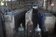 A man works in an oxygen factory in Kabul, Afghanistan, Thursday June 18, 2020. For seven years, Najibullah Seddiqi's oxygen factory sat idle in the Afghan capital Kabul. He shut it down, he says, because corruption and power cuts made it impossible to work. But when the novel coronavirus began racing through his country, he opened the factory's dusty gates and went back to work. Now he refills hundreds of oxygen cylinders a day for free for COVID-19 patients — and at reduced rates for hospitals. (AP Photo/Rahmat Gul)