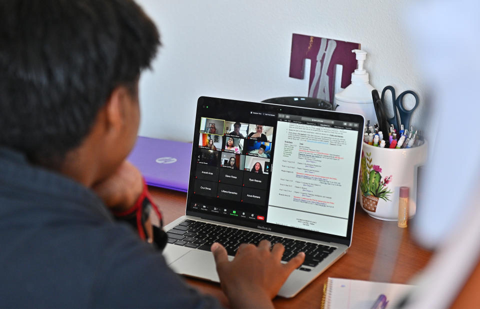 ALBUQUERQUE, NEW MEXICO - AUGUST 17:  Kyalynn Moore-Wilson, a freshman, sits at a desk in her dorm room as she participates in a Zoom meeting for an 'Introduction to Psychology' course as classes begin amid the coronavirus (COVID-19) pandemic on the first day of the fall 2020 semester at the University of New Mexico on August 17, 2020 in Albuquerque, New Mexico. The course will meet in person four times during the fall semester with the remaining classes and coursework completed online. To help prevent the spread of COVID-19, the university has moved to a hybrid instruction model that includes a mixture of in-person and remote classes. According to the school, about 70 percent of classes are being taught online.  (Photo by Sam Wasson/Getty Images)