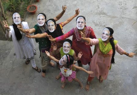 Supporters wearing masks of Hindu nationalist Narendra Modi, the prime ministerial candidate for India's main opposition Bharatiya Janata Party (BJP) celebrate after learning of initial poll results in the northern Indian city of Allahabad May 16, 2014. REUTERS/Jitendra Prakash