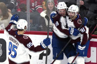 Colorado Avalanche center Alex Newhook, center, celebrates with left wing Andre Burakovsky, left, and center Nazem Kadri after scoring a goal during the third period of an NHL hockey game against the Chicago Blackhawks in Chicago, Friday, Jan. 28, 2022. (AP Photo/Nam Y. Huh)