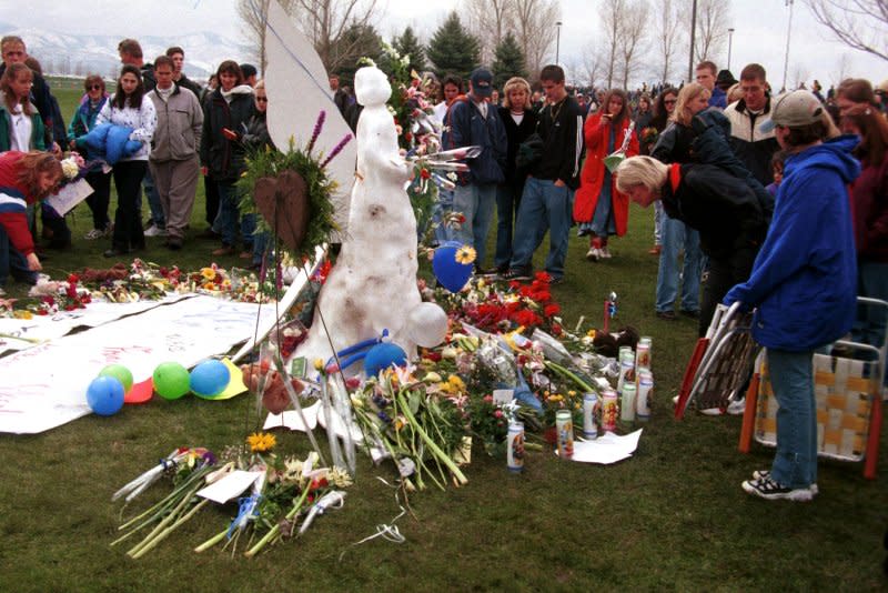 A group of people gather around an angel made of snow in Clement Park adjancent to Columbine High School on April 25, 1999, as the public outpouring of sympathy continues to grow in the wake of the April 20 shooting at the school in Littleton, Colo. File Photo by Jim Ruymen/UPI