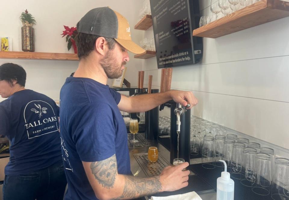 A bartender pours a beer at Tall Oaks Farm + Brewery in Farmingdale.
