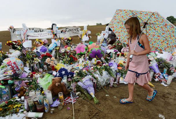 PHOTO: Avery Gillespie, 7, places flowers at a memorial setup across the street from the Century 16 movie theatre, July 27, 2012, in Aurora, Colo. (Kevork Djansezian/Getty Images)