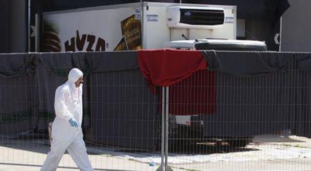 A member of a forensic team walks in front of a truck in which more than 70 bodies were found, at a customs building with refrigeration facilities in the village of Nickelsdorf, Austria. Source: Reuters