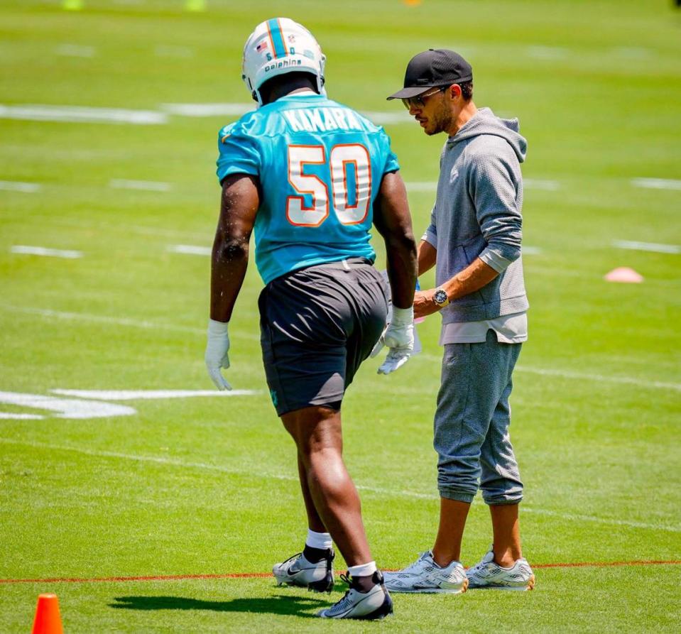 Miami Dolphins coach Mike McDaniel works with Mohamed Kamara (50) during practice at the Baptist Health Training Complex.