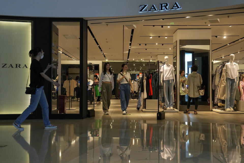 People tour by a ZARA flagship store at a shopping mall in Beijing, Wednesday, June 21, 2023. Foreign companies are shifting investments and their Asian headquarters out of China as confidence plunges following the expansion of an anti-spying law and other challenges, a business group said Wednesday. (AP Photo/Andy Wong)