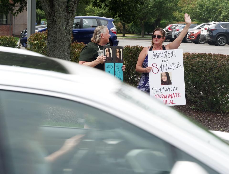 Sarah Forbes of Mansfield and Jill Sheridan of Bridgewater acknowledge the supportive horn honking at a protest at the Norfolk district attorney's office in Canton on Monday Aug. 21, 2023, calling for a deeper investigation into the death of Sandra Birchmore.