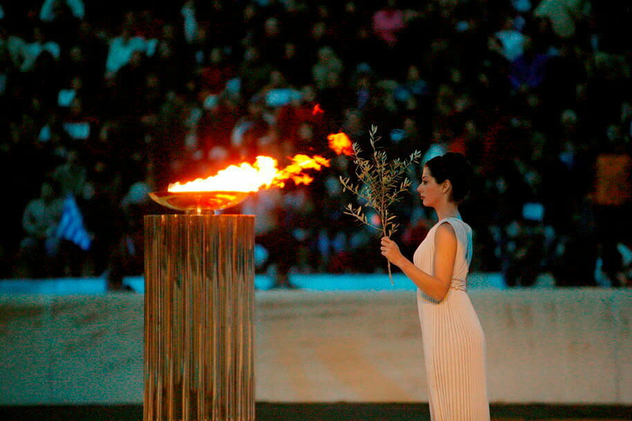 Au Stade panathénaïque, site des premiers Jeux de 1896, est traditionnellement allumée la torche olympique, qui effectuera ensuite tout un périple jusqu’à la ville hôte des Jeux. Ici, en 2004, l’actrice Thalia Prokopiou en « grande prêtresse » pour les JO d’Athènes.  - Credit:AKG-Images/Picture-alliance