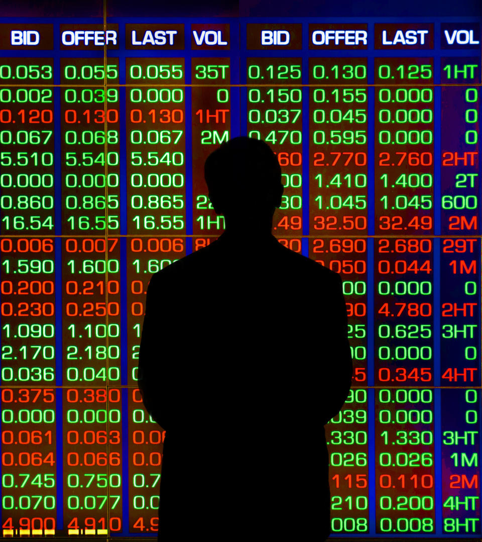 Composite image:Businessman standing before stock price display at business district of Sydney.(NOTE there are no companies names on this board as I have removed them by cropping them out of image)