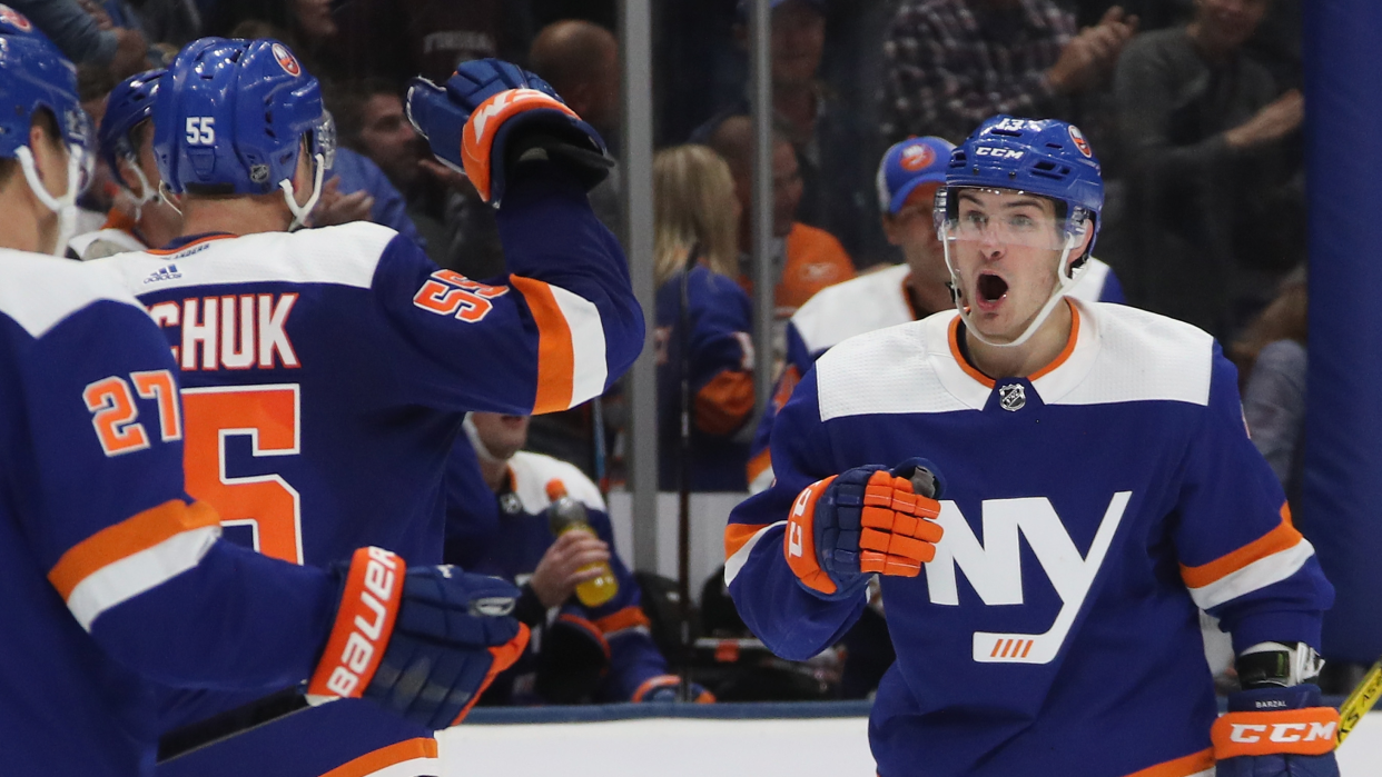 UNIONDALE, NEW YORK - OCTOBER 14: Mathew Barzal #13 of the New York Islanders celebrates the game tying goal by Anders Lee #27 against the St. Louis Blues at NYCB Live's Nassau Coliseum on October 14, 2019 in Uniondale, New York. The Islanders defeated the Blues 3-2 in overtime. (Photo by Bruce Bennett/Getty Images)