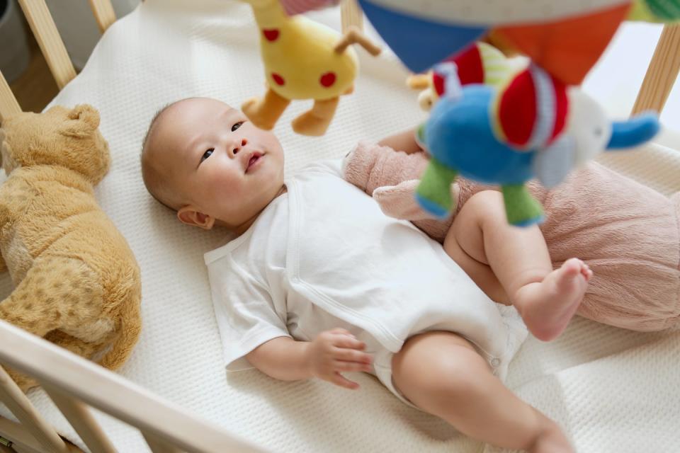 A mobile in motion can keep a baby entertained. <a href="https://www.gettyimages.com/detail/photo/asian-newborn-baby-feeling-joyful-and-happy-with-royalty-free-image/1372675707" rel="nofollow noopener" target="_blank" data-ylk="slk:Nattakorn Maneerat/iStock via Getty Images;elm:context_link;itc:0;sec:content-canvas" class="link ">Nattakorn Maneerat/iStock via Getty Images</a>