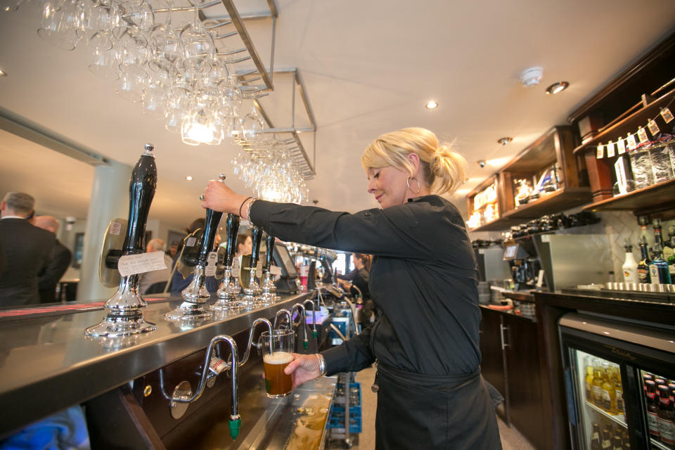 Barmaid Rochelle Chapman pulls a pint of ale at the new JD Wetherspoon pub the Hope and Champion which has opened at the M40 Services at Beaconsfield, Buckinghamshire.   (Photo by Steve Parsons/PA Images via Getty Images)