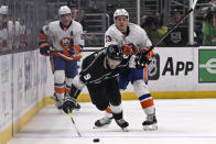 Los Angeles Kings right wing Adrian Kempe (9) efforts to get to the puck against New York Islanders center Mathew Barzal (13) during the second period of an NHL hockey game in Los Angeles, Monday, March 11, 2024. (AP Photo/Alex Gallardo)