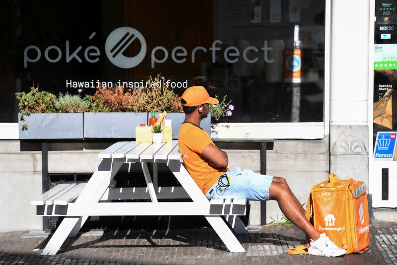 A bicycle courier from Takeaway waits for his delivery during the heatwave in Utrecht