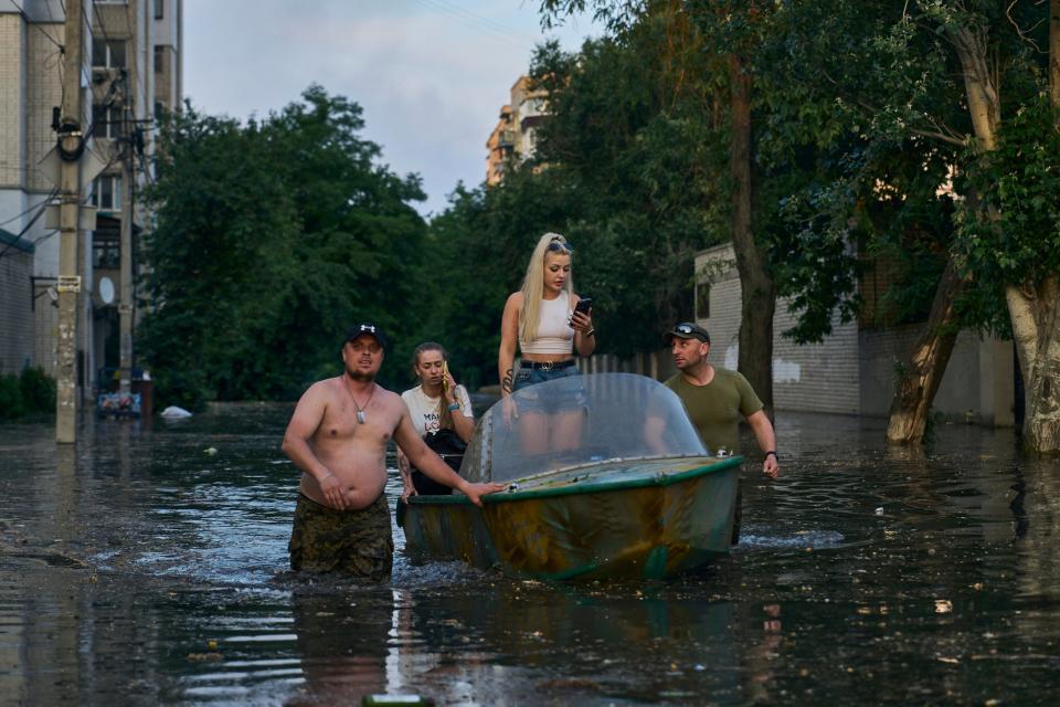 Residents wade through floodwater (Copyright 2023 The Associated Press. All rights reserved.)