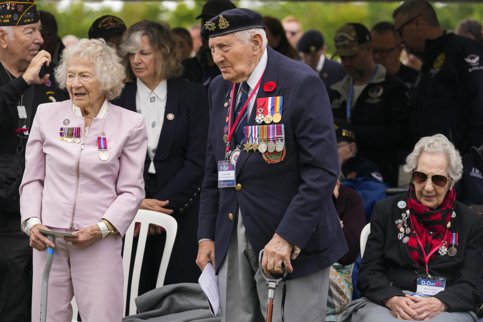 British World War II veterans Mervyn Kersh, center, and Marie Scott, right, attend a service at the Pegasus Bridge memorial in Benouville, Normandy, France, Wednesday, June 5, 2024. World War II veterans from across the United States as well as Britain and Canada are in Normandy this week to mark 80 years since the D-Day landings that helped lead to Hitler's defeat. (AP Photo/Virginia Mayo)