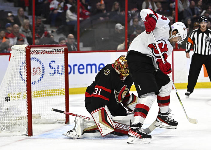 The puck enters the net behind Ottawa Senators goaltender Anton Forsberg (31) on a shot from New Jersey Devils left wing Erik Haula (56), not shown, as New Jersey Devils right wing Nathan Bastian (14) plays at the top of the crease, during first period of an NHL hockey game in Ottawa, on Saturday, Nov. 19, 2022. (Justin Tang /The Canadian Press via AP)