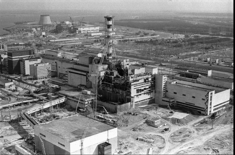 FILE - This 1986 file photo shows an aerial view of the Chernobyl nuclear plant in Chernobyl, Ukraine showing damage from an explosion and fire in reactor four on April 26, 1986 that sent large amounts of radioactive material into the atmosphere. A massive shelter has finally been installed over the exploded reactor at the Chernobyl nuclear plant, one of the most ambitious engineering projects in the world. The half-cylinder-shaped shelter began being moved toward the reactor on a system of hydraulic jacks two weeks ago and reached its destination Tuesday, Nov. 29, 2016 a significant step toward liquidating the remains of the world's worst nuclear accident, 30 years ago in what is now Ukraine. (AP Photo/Volodymyr Repik, File)