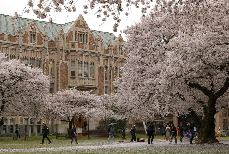 FILE - In this April 3, 2019, file photo, students walk between classes on the University of Washington campus in Seattle. Five Black police officers claiming racism at the University of Washington have filed claims for $8 million in damages. They say they were routinely insulted and demeaned by co-workers and supervisors. KOMO-TV reported Tuesday, June 22, 2021, that the officers say they were disciplined and denied promotions because of their race. (AP Photo/Ted S. Warren, File)