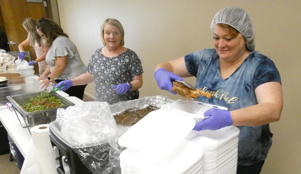 Jennifer Morgan, home care coordinator, right, puts chicken in a to-go container while Cassie Herschler, executive director, waits to add green beans during the Crawford County Council on Aging's chicken barbecue on May 11. Morgan died one week later.