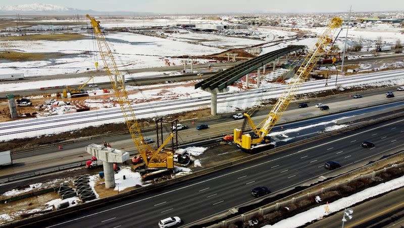 Workers construct a bridge over I-15 on the West Davis Corridor near Farmington on Tuesday, March 28, 2023.