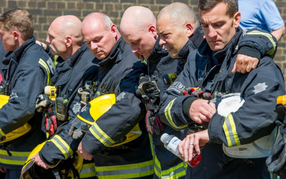 Firefighters from Kensington attend a minute's silence at the site of Grenfell Tower - Credit: Eddie Mulholland for The Telegraph