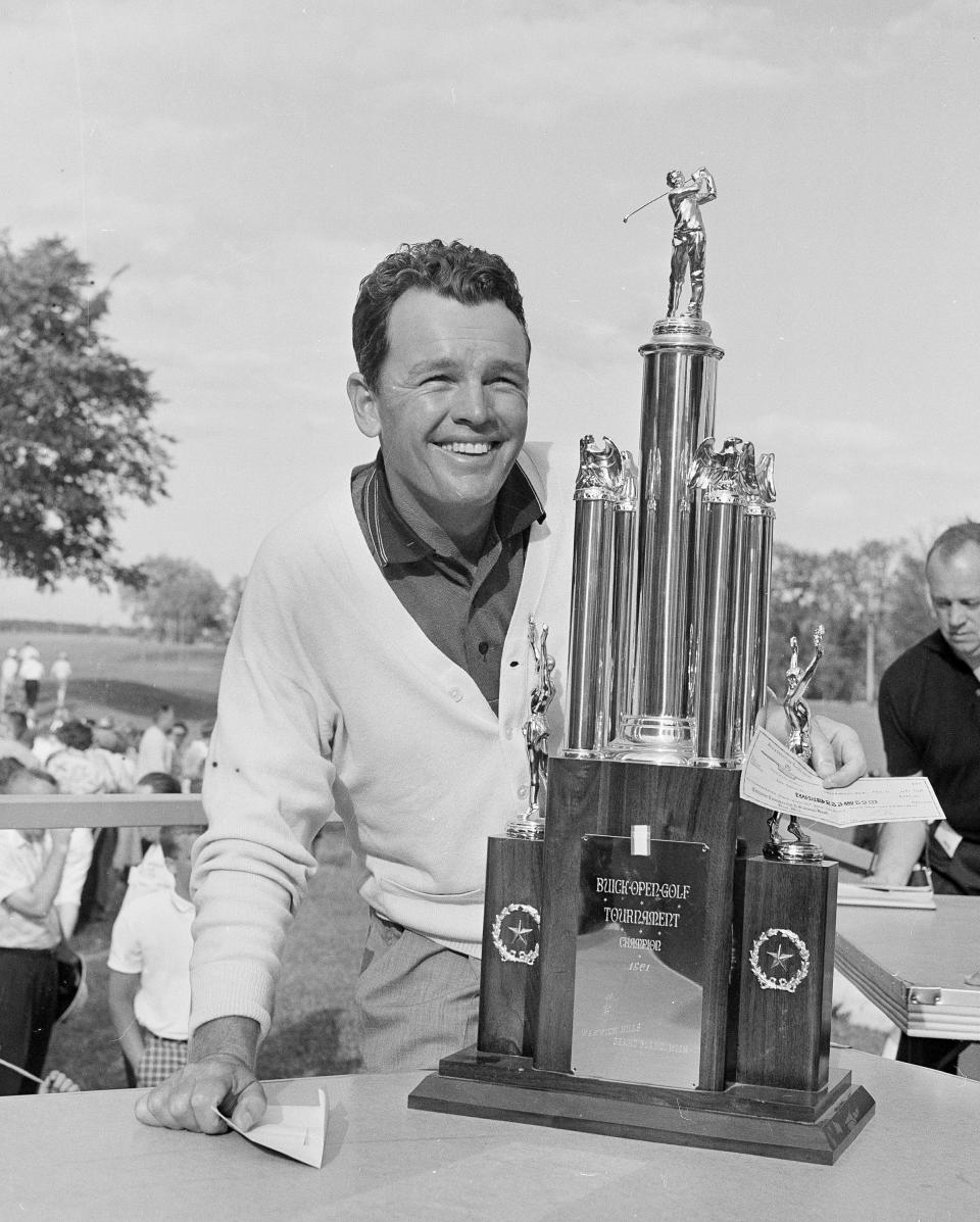 FILE - Golfer Jack Burke, Jr. holds his check while posing with the trophy after winning the Flint Open golf tournament in Grand Blanc, Mich., July 3, 1961. Jack Burke Jr., the oldest living Masters champion who staged the greatest comeback ever at Augusta National for one of his two majors, died Friday morning, Jan. 19, 2024, in Houston. He was 100. (AP Photo/Preston Stroup, File)