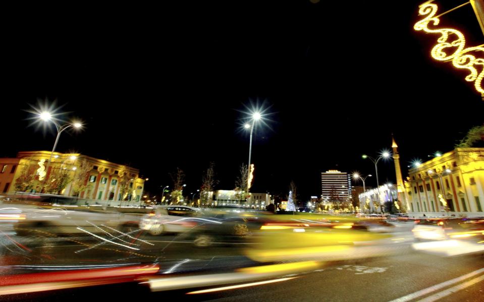 FILE - Traffic passes in Albania's capital main Skanderbeg Square in Tirana, Albania, Wednesday, Dec. 17, 2014. The European Union and Germany say they will give Albania nearly $88 million to turn the three main bus lines in the capital Tirana electric, part of helping the Balkan country meet requirements to join the 27-nation bloc. (AP Photo/Hektor Pustina, File)