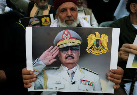 A Libyan man carries a picture of Khalifa Haftar during a demonstration to support Libyan National Army offensive against Tripoli, in Benghazi, Libya April 12, 2019. REUTERS/Esam Omran Al-Fetori/File Photo