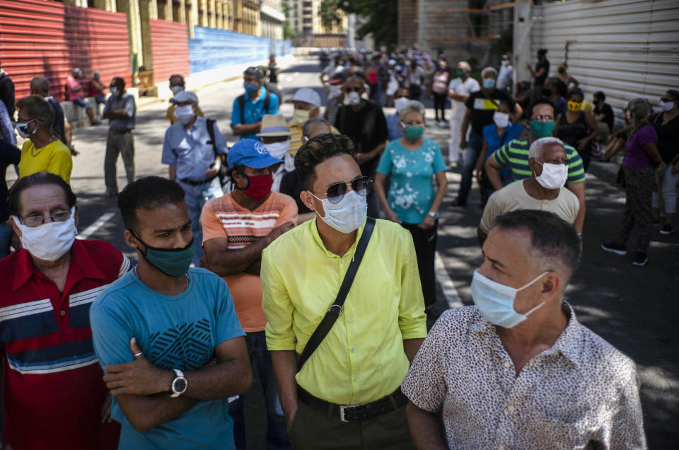 Gente con mascarillas como protección en medio de la pandemia del coronavirus espera para entrar al Teatro Martí para rendir sus últimos respetos a la difunta cantante y actriz cubana Rosita Fornés en un velorio público en La Habana, el martes 16 de junio del 2020. Fornés murió la semana pasada en Miami a los 97 años. Sus restos fueron trasladados a Cuba para su entierro. (AP Foto/Ramón Espinosa)